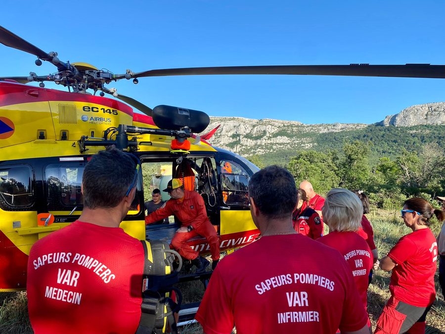 Sapeurs-pompiers volontaires devant un hélicoptère de la sécurité civile